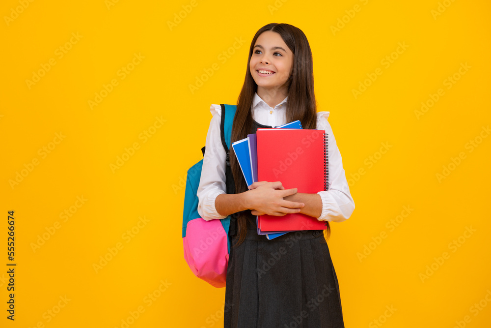 Back to school. Teenager school girl hold book and copybook ready to learn. School children with school bag on isolated yellow studio background. Back to school. Teenager school girl hold book and copybook ready to learn. School children with school bag on isolated yellow studio background.
