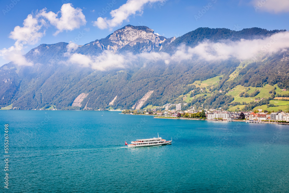 Swiss alps and lake Lucerne with ferry boat arriving at harbor, Switzerland