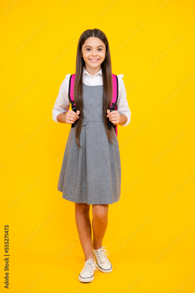 Back to school. Teenager schoolgirl in school uniform with bag. School children on isolated studio background. Back to school. Teenager schoolgirl in school uniform with bag. School children on isolated studio background.