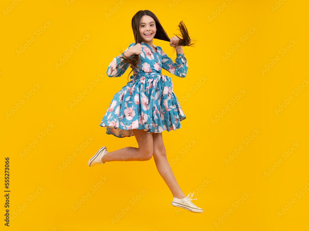 Full length overjoyed teenager kid girl 12 13 14 year jumping old isolated on yellow background studio. Funny jump. Child in summer movement dress. Full length overjoyed teenager kid girl 12 13 14 year jumping old isolated on yellow background studio. Funny jump. Child in summer movement dress.