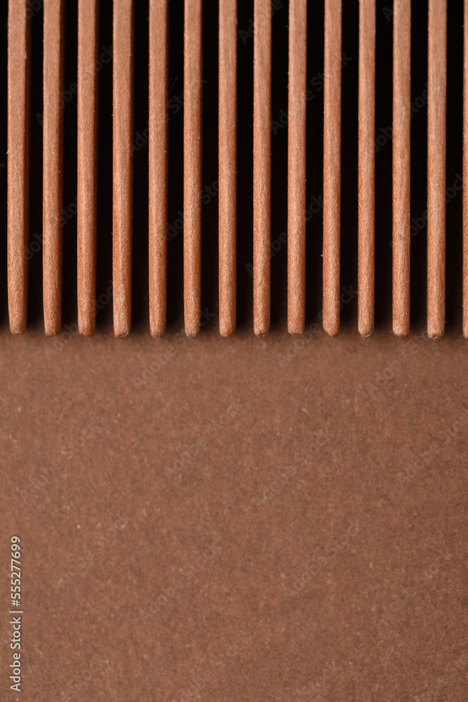 Closeup view of wooden hair comb on brown background Closeup view of wooden hair comb on brown background