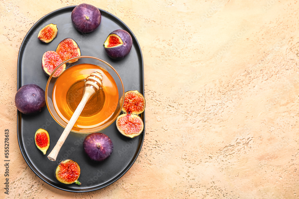 Plate with fresh figs and bowl of honey on color background Plate with fresh figs and bowl of honey on color background