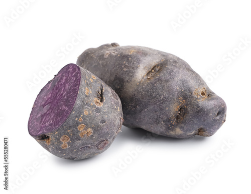 Cut and whole raw purple potatoes on white background