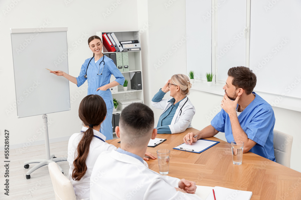 Obraz premium Doctor giving lecture near flipchart in conference room