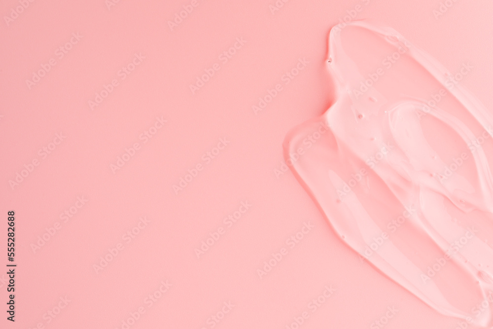 Sample of transparent gel on pink background, top view. Space for text