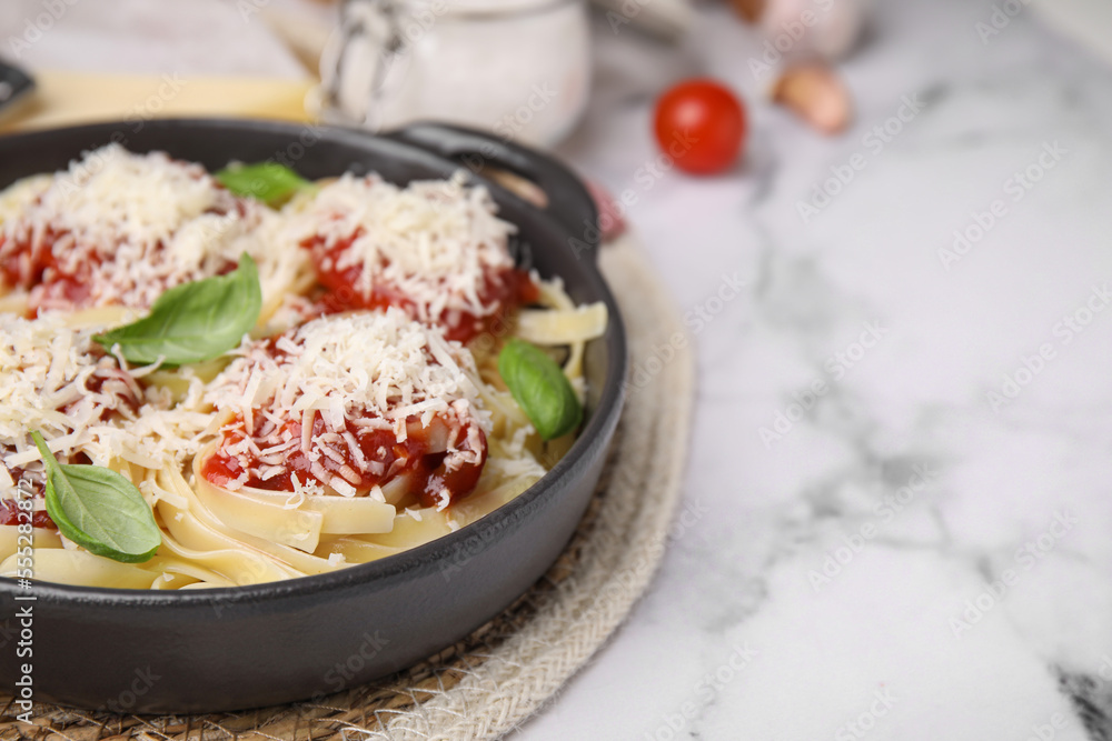 Delicious pasta with tomato sauce, basil and parmesan cheese on white marble table, closeup. Space for text Delicious pasta with tomato sauce, basil and parmesan cheese on white marble table, closeup. Space for text