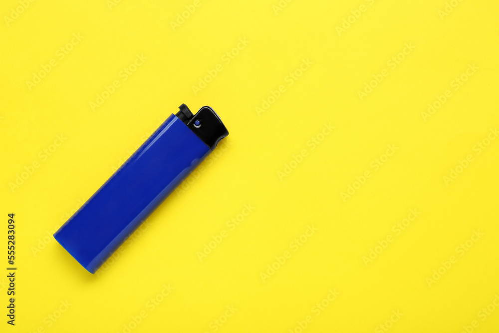 Stylish small pocket lighter on yellow background, top view. Space for text Stylish small pocket lighter on yellow background, top view. Space for text