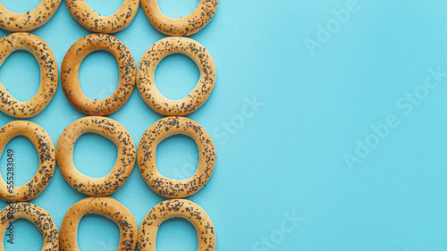 Many delicious ring shaped Sushki (dry bagels) on light blue background, flat lay. Space for text