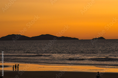 Coronado Islands off Baja Mexico at sunset. People play at the beach in Southern California. 