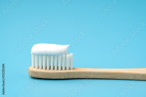 New toothbrush with toothpaste closeup on blue background closeup photo