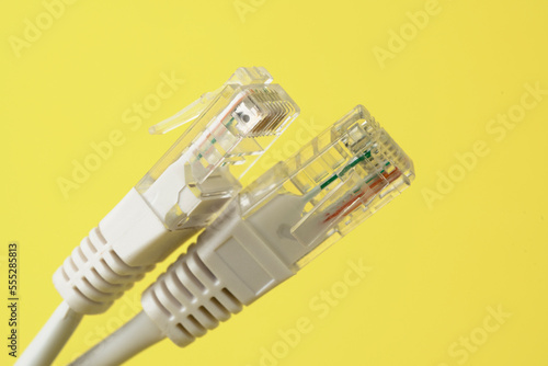 Network connection, internet connection and computer technology concept, close-up of ethernet cable connector, on yellow background