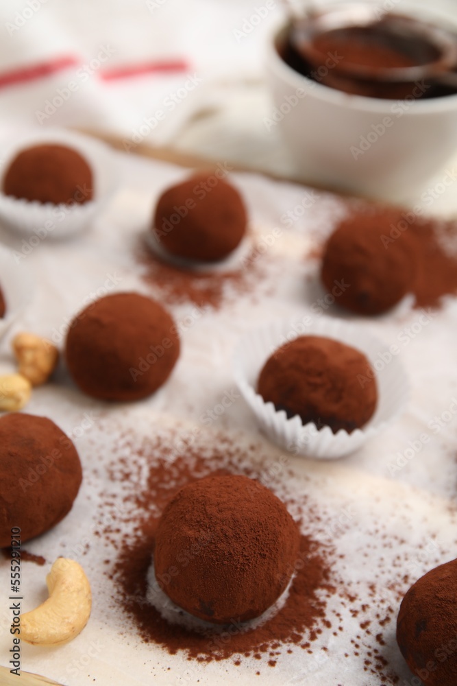Delicious chocolate truffles powdered with cocoa on table, closeup Delicious chocolate truffles powdered with cocoa on table, closeup