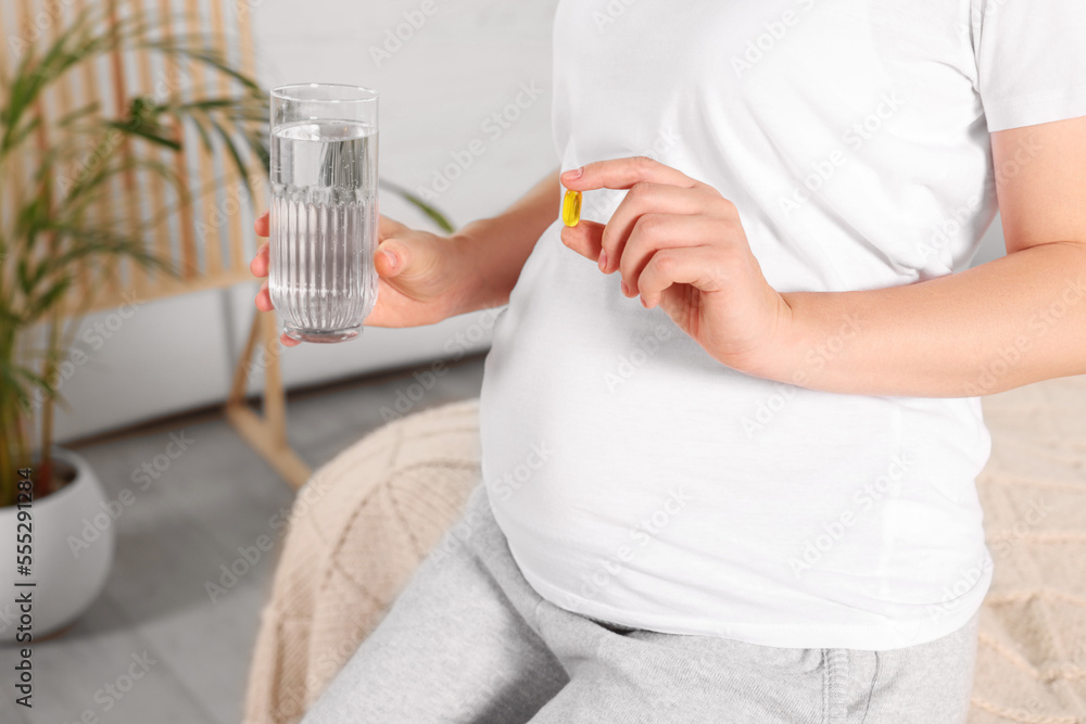 Pregnant woman taking pill at home, closeup Pregnant woman taking pill at home, closeup