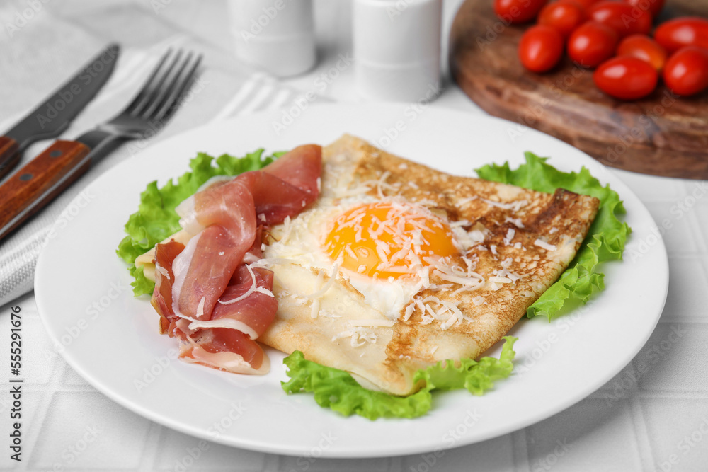 Delicious crepe with egg served on white tiled table. Breton galette Delicious crepe with egg served on white tiled table. Breton galette
