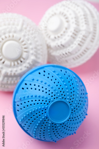 Dryer balls for washing machine on pink background, closeup. Laundry detergent substitute