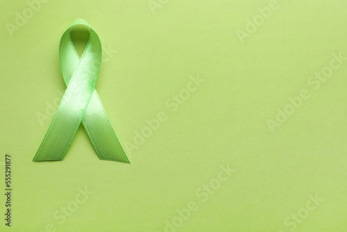 World Mental Health Day. Green ribbon on color background, top view with space for text