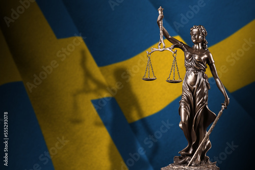 Sweden flag with statue of lady justice and judicial scales in dark room. Concept of judgement and punishment, background for jury topics photo