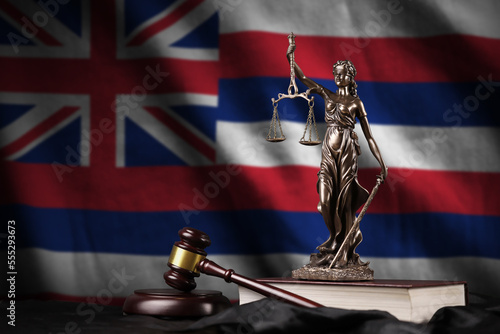 Hawaii US state flag with statue of lady justice, constitution and judge hammer on black drapery. Concept of judgement and punishment photo