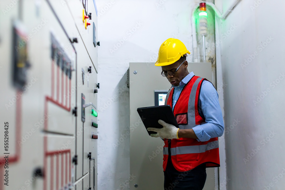 Electrical engineer working in control room. Electrical engineer man checking Power Distribution Cabinet in the control room Electrical engineer working in control room. Electrical engineer man checking Power Distribution Cabinet in the control room