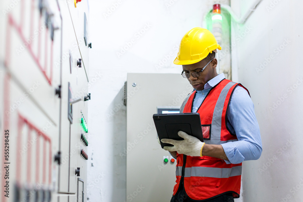 Electrical engineer working in control room. Electrical engineer man checking Power Distribution Cabinet in the control room Electrical engineer working in control room. Electrical engineer man checking Power Distribution Cabinet in the control room