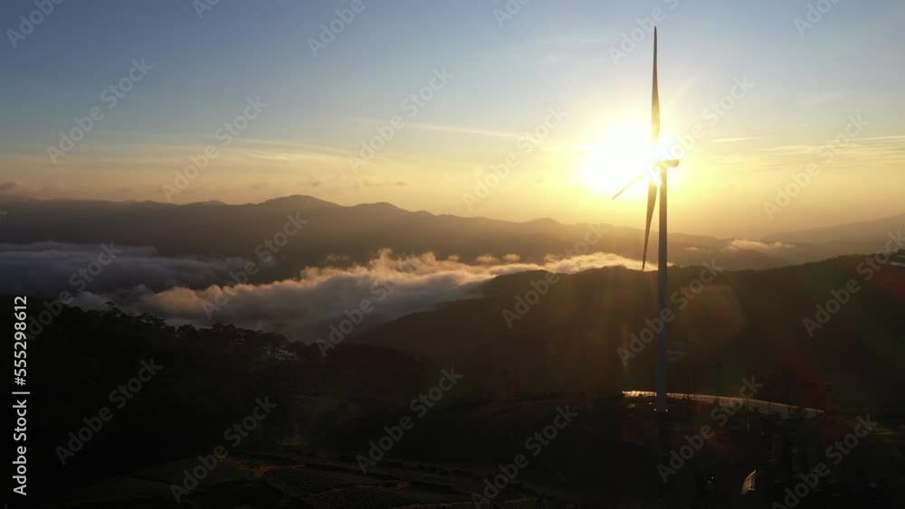 WIND TURBINES AT SUNRISE IN HEAVY FOG. WIND FARM GENERATING GREEN ENERGY, DA LAT, VIETNAM WIND TURBINES AT SUNRISE IN HEAVY FOG. WIND FARM GENERATING GREEN ENERGY, DA LAT, VIETNAM