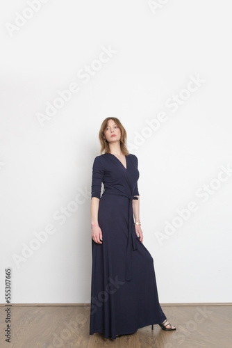 Serie of studio photos of young female model in dark blue maxi viscose wrap dress.