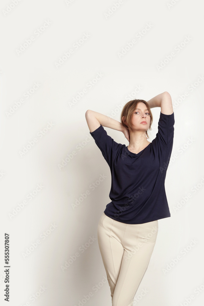 Serie of studio photos of young female model wearing simple comfortable outfit, organic cotton blue blouse and white trousers Serie of studio photos of young female model wearing simple comfortable outfit, organic cotton blue blouse and white trousers