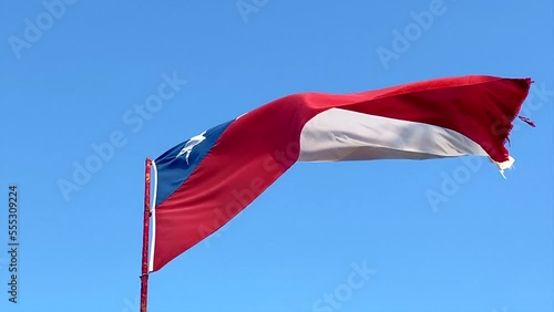 Waving flag of Chile in the blue sky
