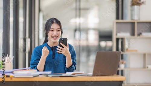 Image of a happy excited young entrepreneur Asian woman in workplace, winner, feel excited, Happy, joyful, Surprised and business finance concept.