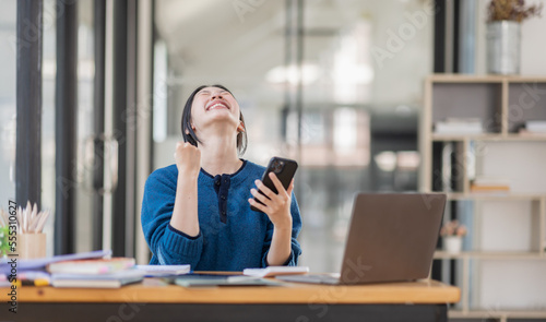 Image of a happy excited young entrepreneur Asian woman in workplace, winner, feel excited, Happy, joyful, Surprised and business finance concept. © David