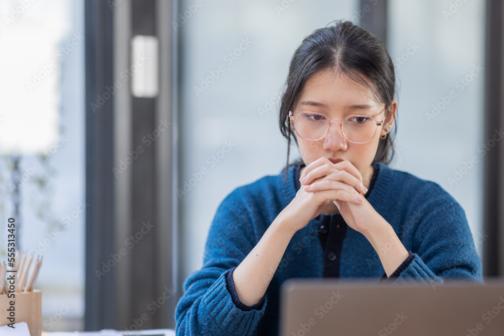 Portrait of tired young business Asian woman work with documents tax laptop computer in office. Sad, unhappy, Worried, Depression, or employee life stress concept. Portrait of tired young business Asian woman work with documents tax laptop computer in office. Sad, unhappy, Worried, Depression, or employee life stress concept.