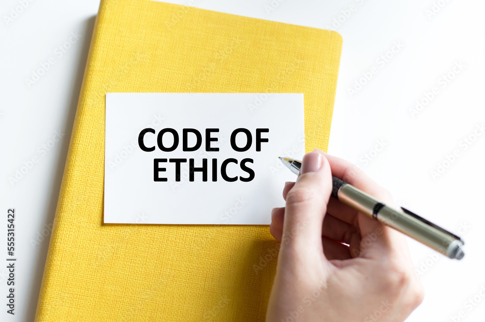 Businessman putting a card with text code of ethics Businessman putting a card with text code of ethics