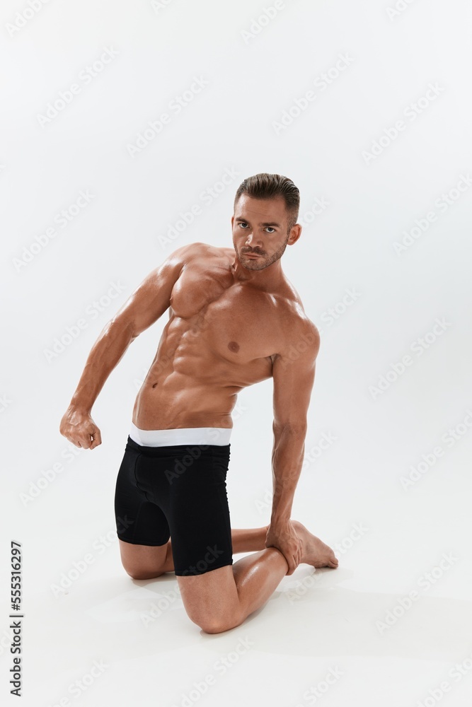 Man athletic body bodybuilder in briefs with naked torso abs full-length in the background, fitness classes. Advertising, sports, active lifestyle, competition, challenge concept. Man athletic body bodybuilder in briefs with naked torso abs full-length in the background, fitness classes. Advertising, sports, active lifestyle, competition, challenge concept.