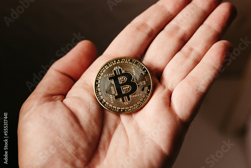 hands holding golden cryptocurrencies photo
