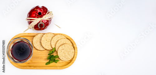 Pomegranate  red wine and round bread on a wooden tray on a white holiday background for Rosh Hashanah