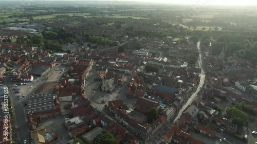 Drone shot puling out off historic English market town centre with church at golden hour sunrise photo