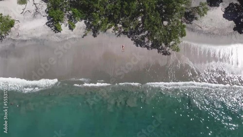 Drone view of a girl lying on a paradise beach in Costa Rica photo