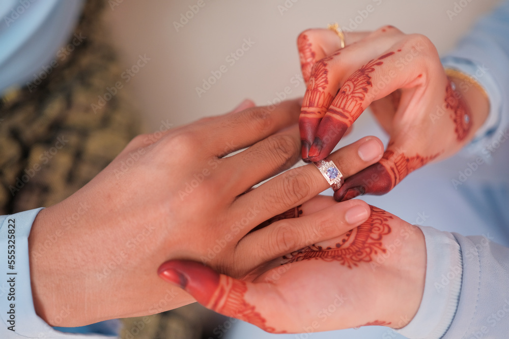 Malay wedding bride put a ring on her groom.