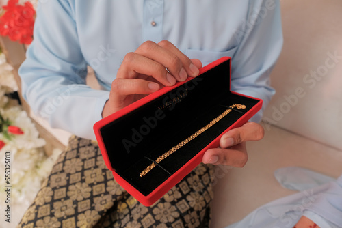 The groom put the wedding bracelet to the bride during solemnization ceremony. Family and happiness concept.