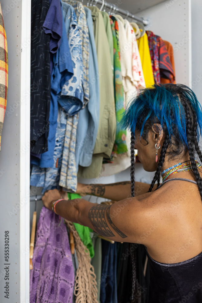 Obraz premium indigenous non-binary artist with blue hair getting dressed