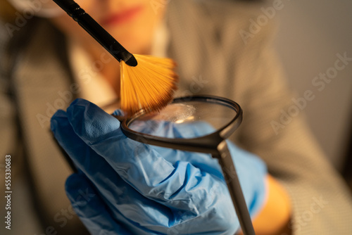 Billede på lærred Forensic fingerprint analysis, criminalist woman collects latent fingerprints us