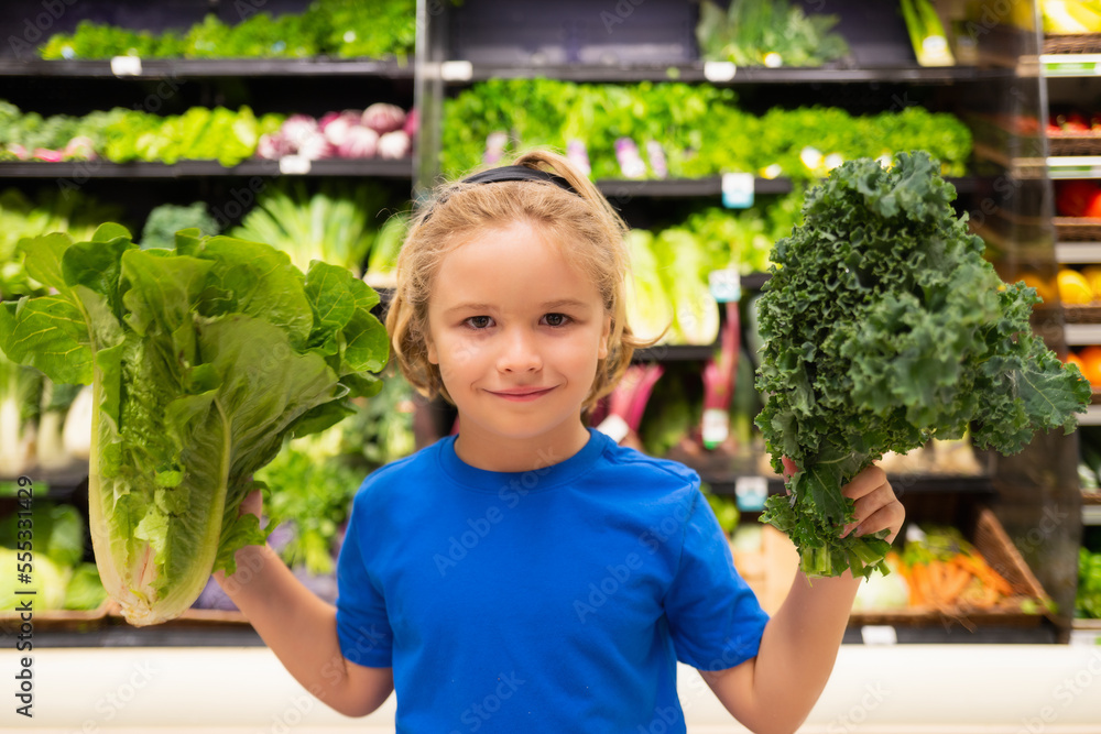 Kid with vegetables at grocery store. Healthy food for kids. Portrait of smiling little child with shopping bag at grocery store or supermarket. Kid with vegetables at grocery store. Healthy food for kids. Portrait of smiling little child with shopping bag at grocery store or supermarket.