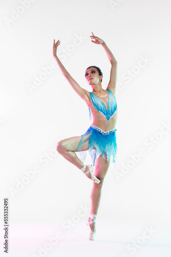 Professional Japanese Female Ballet Dancer Posing in Pale and Blue Dress With Flying Green Cloth In Hands Against White Background.