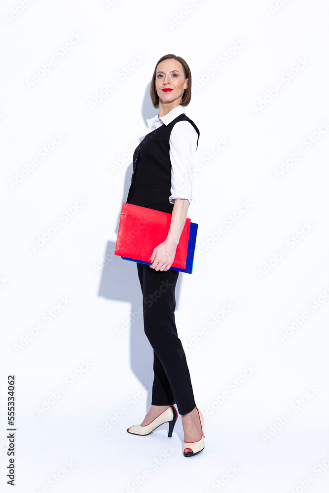 Women In Business. Full Length Portrait of Winsome Positive Confident Caucasian Business Woman in White Shirt Posing With Folders Over White Background. Women In Business. Full Length Portrait of Winsome Positive Confident Caucasian Business Woman in White Shirt Posing With Folders Over White Background.