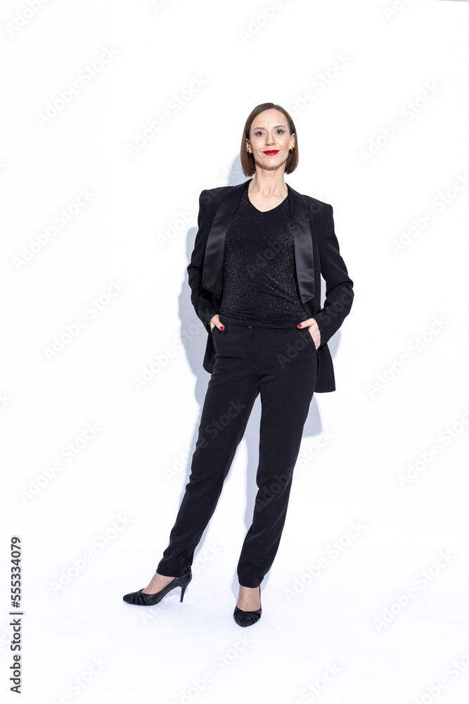 Women In Business. Full Length Portrait of Winsome Positive Confident Caucasian Business Woman in Black Suit Posing Over White Background. Women In Business. Full Length Portrait of Winsome Positive Confident Caucasian Business Woman in Black Suit Posing Over White Background.