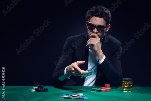 Gambling Concepts. One Emotional Handsome Caucasian Brunet Cards Player At Pocker Table With Chips Flying and Cards While Playing and Drinking
