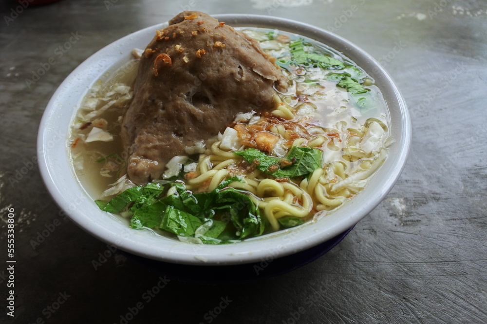 Indonesian authentic and traditional meatballs soup - Bakso soup on white cup and marble background Indonesian authentic and traditional meatballs soup - Bakso soup on white cup and marble background