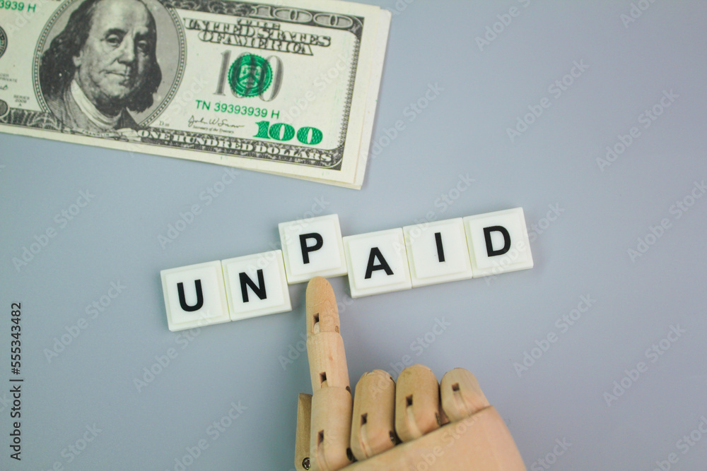 paper money and hand pushing the letter P with the word UNPAID. unpaid concept. payment concept paper money and hand pushing the letter P with the word UNPAID. unpaid concept. payment concept