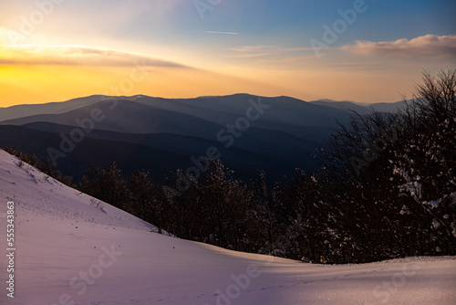 panorama of snow-capped mountains at sunset during a cold winter  mighty mountain peaks in the Polish Bieszczady mountains  mountain vegetation covered with snow © Jakub