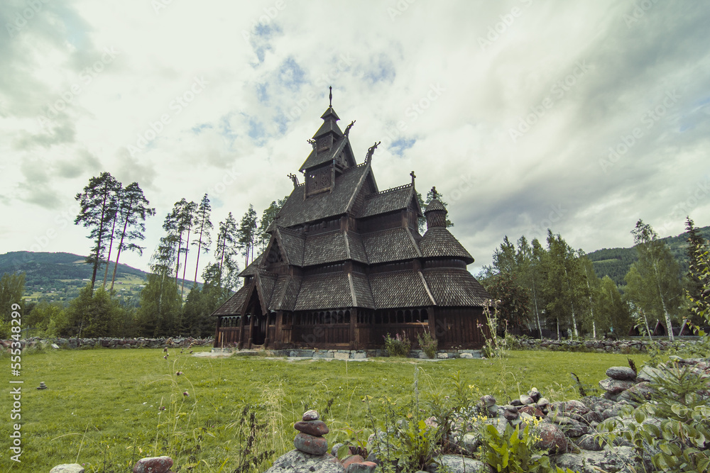 Urnes stavkirke at highland landscape photo. Beautiful nature scenery photography with cloudy sky on background. Idyllic scene. High quality picture for wallpaper, travel blog, magazine, article Urnes stavkirke at highland landscape photo. Beautiful nature scenery photography with cloudy sky on background. Idyllic scene. High quality picture for wallpaper, travel blog, magazine, article